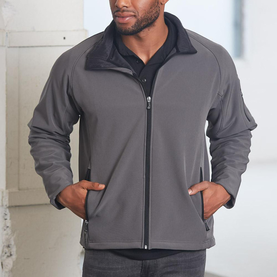 Charcoal grey softshell jacket with navy collar and contrast zipper, featuring side pockets and stretchy fabric