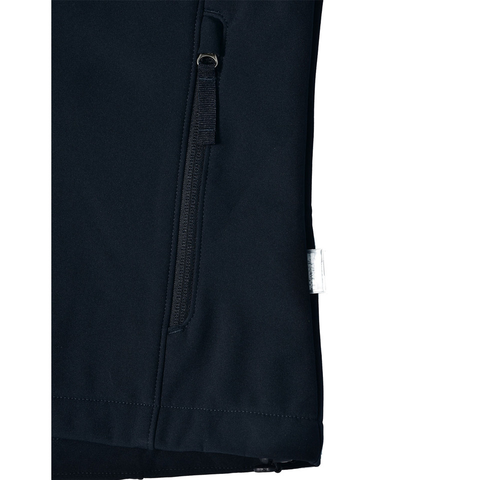 Close-up of navy softshell jacket hem showing angled zip pocket, woven loop pull and white care label