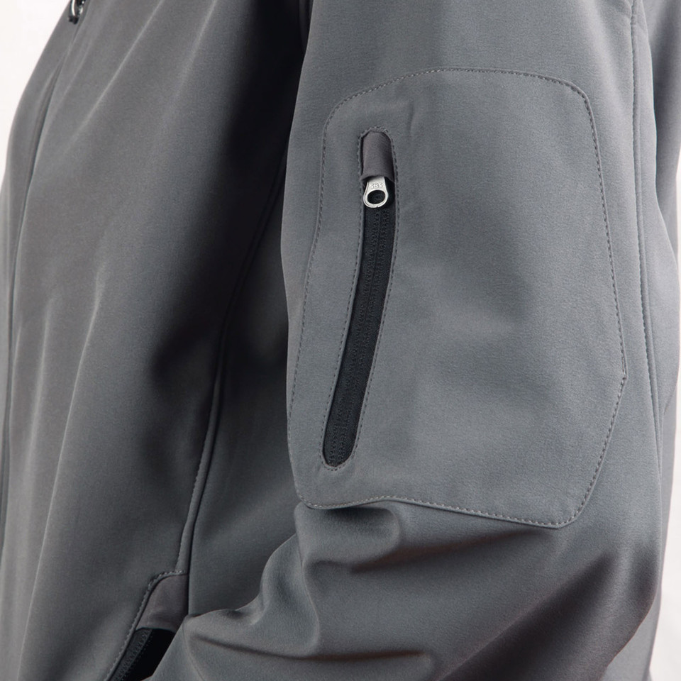 Slate grey softshell jacket close-up showing angled chest pocket and sleeve zip pocket with black zipper tape