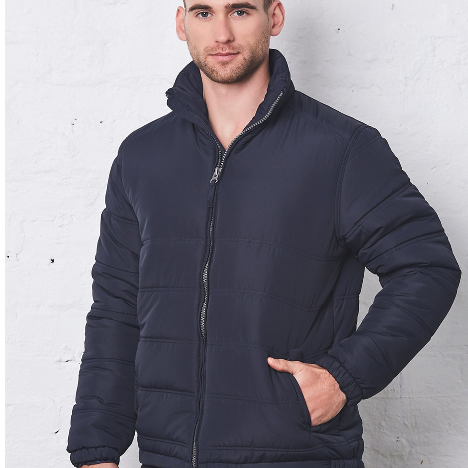 Man wearing navy quilted puffer jacket with zip front, stand collar and side pockets
