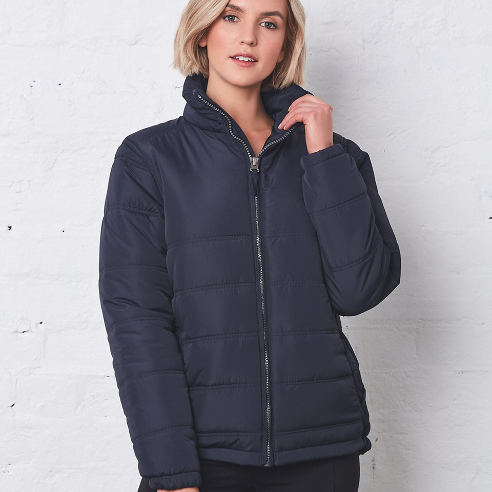 Woman wearing navy heavy quilted puffer jacket with stand collar and full-length silver zip