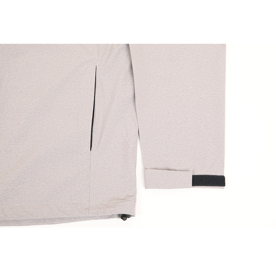 Light beige waterproof jacket showing zippered side pocket and dark charcoal sleeve tab detail