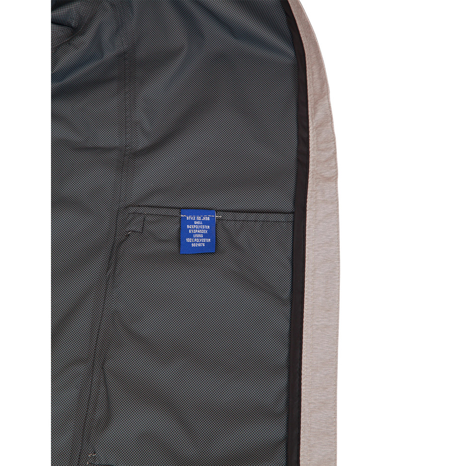 Grey waterproof performance jacket interior showing charcoal lining with internal zippered pocket and blue care label