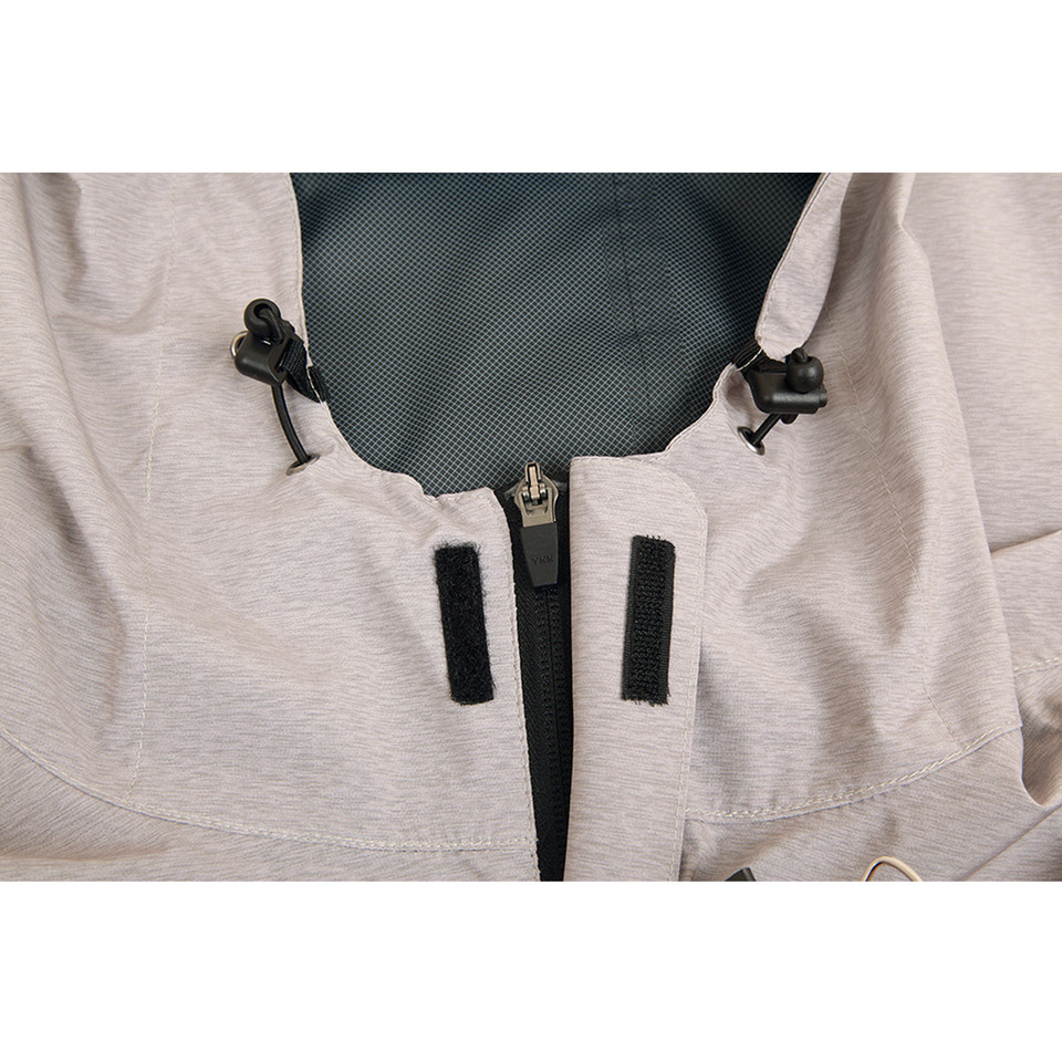 Close-up of light grey zip-up jacket showing black centre zip, velcro chest tabs, drawcord hood, and dark mesh lining