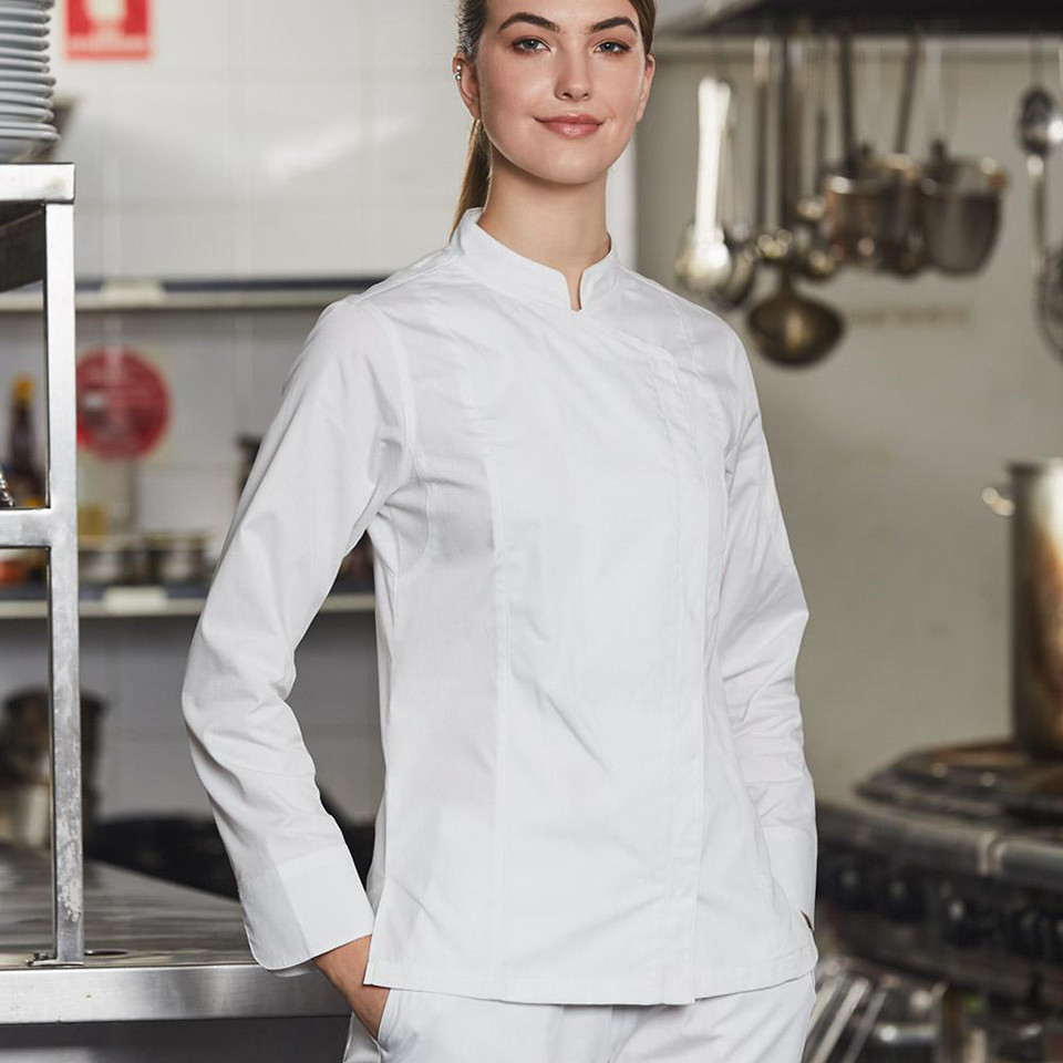 Woman wearing white long-sleeve chef jacket with mandarin collar in a professional kitchen setting