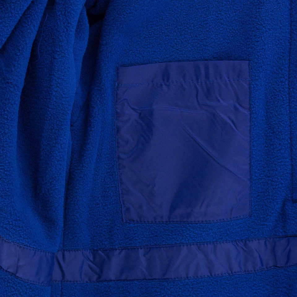 Royal blue fleece jacket close-up showing contrast nylon chest pocket and ripstop hem panel detail