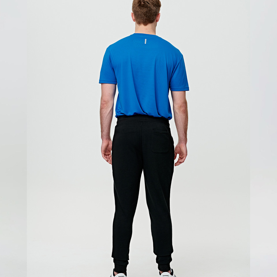 Back view of royal blue tee with black French terry jogger pants showing tapered fit and cuffed ankles