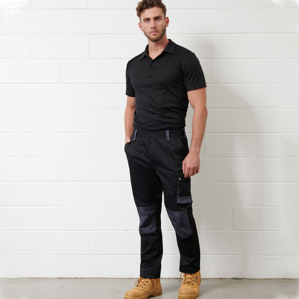 Black and charcoal utility cargo work pants with contrast knee panels and multiple pockets, paired with black polo