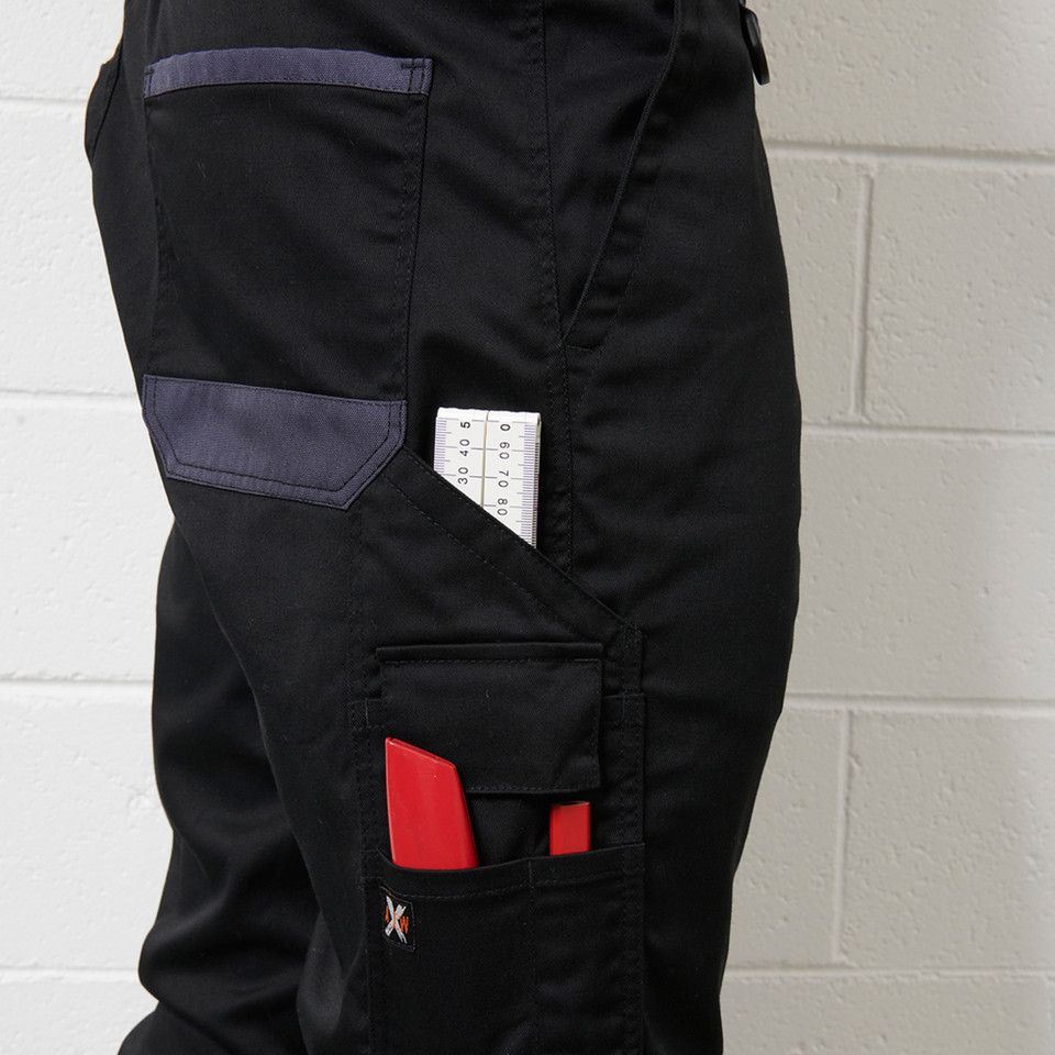 Black cargo work pants with charcoal grey contrast trim, multiple cargo pockets with red accent panels and ruler pocket