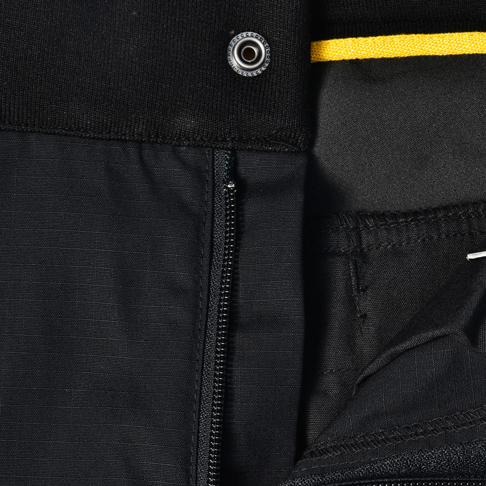 Black ripstop work pants with zipper fly, metal snap closure, and yellow drawstring detail