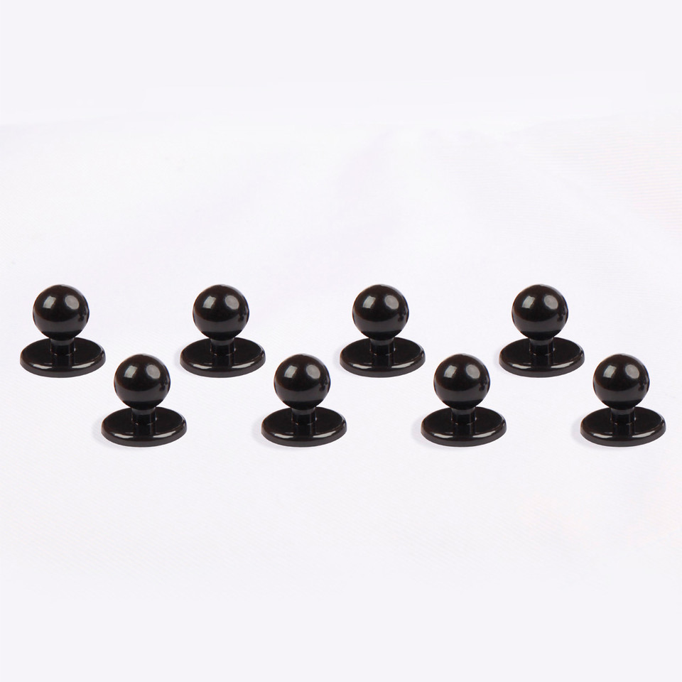 Eight black dome-shaped chef buttons with flat circular bases arranged in two rows