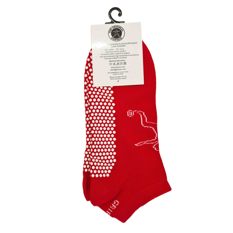 Bright red ankle socks with white grip dots on sole and foot outline design, displayed with hang tag
