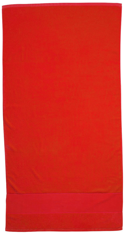 Flat lay of a bright red cotton velour beach towel with contrast hemmed border panel