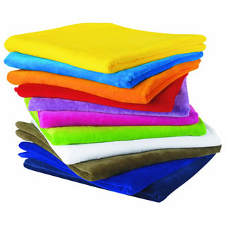 Stack of cotton velour beach towels in yellow, blue, orange, red, purple, magenta, lime green, white, khaki and royal blue