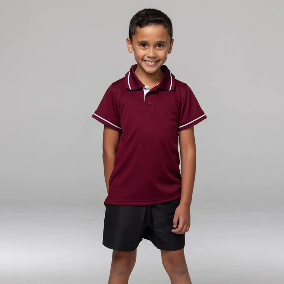Boy wearing maroon kids polo shirt with white tipping on collar and sleeve cuffs