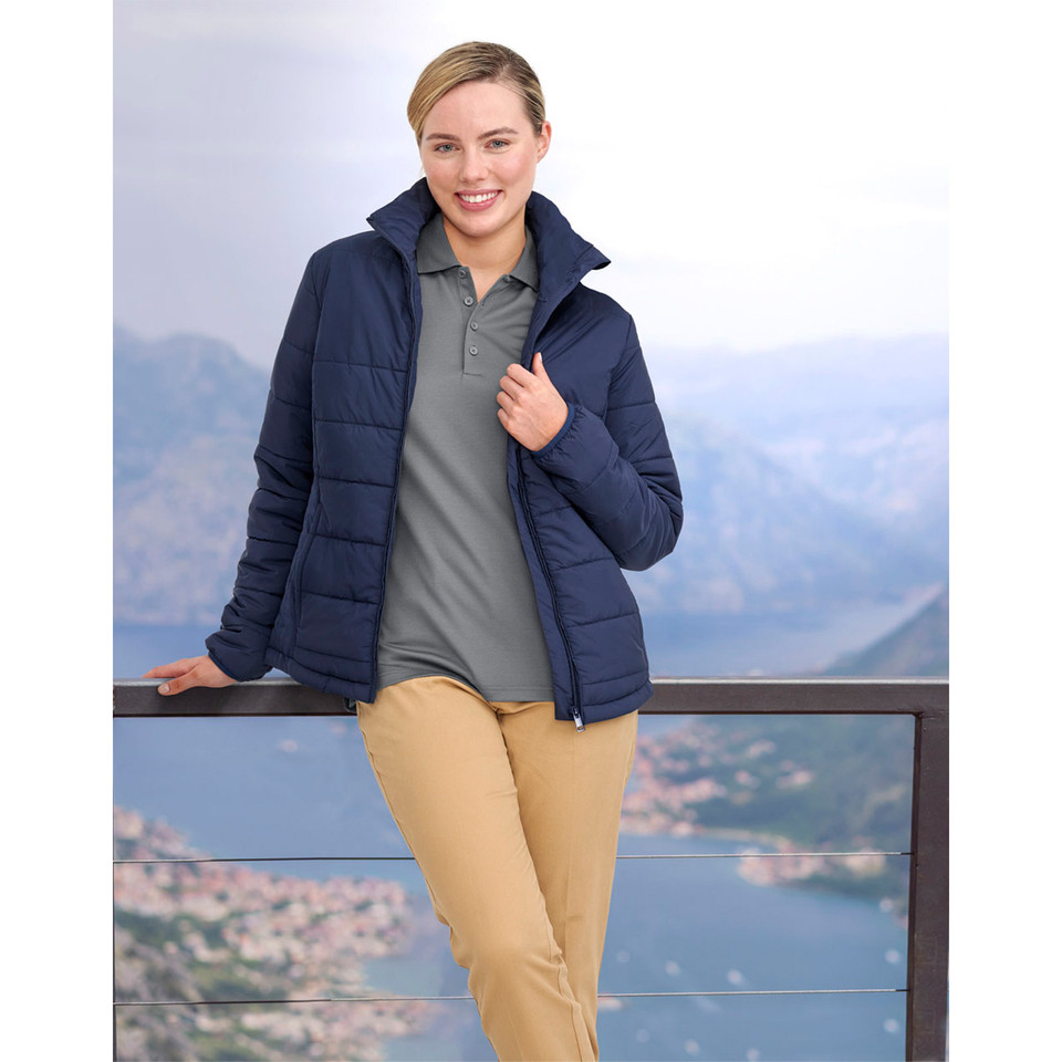 Woman wearing navy quilted puffer jacket with zip front and horizontal baffle panels over grey polo
