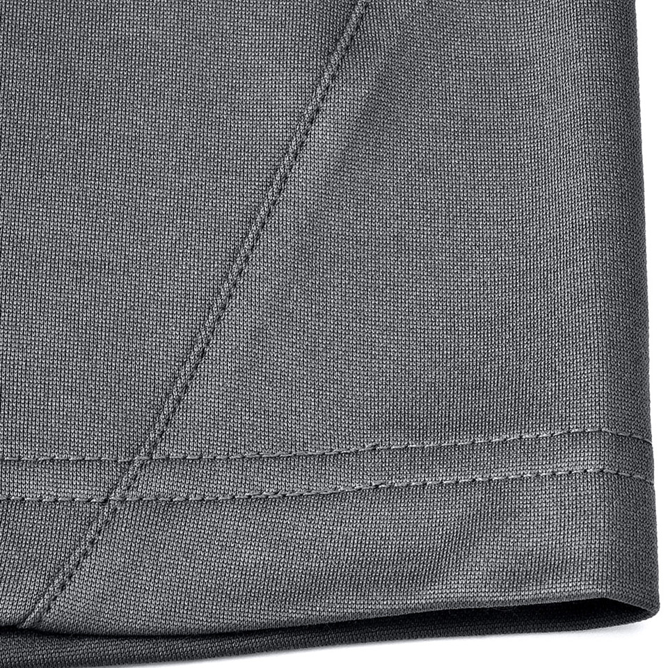 Charcoal grey polo shirt hem detail showing contrast black trim and flatlock stitching seams