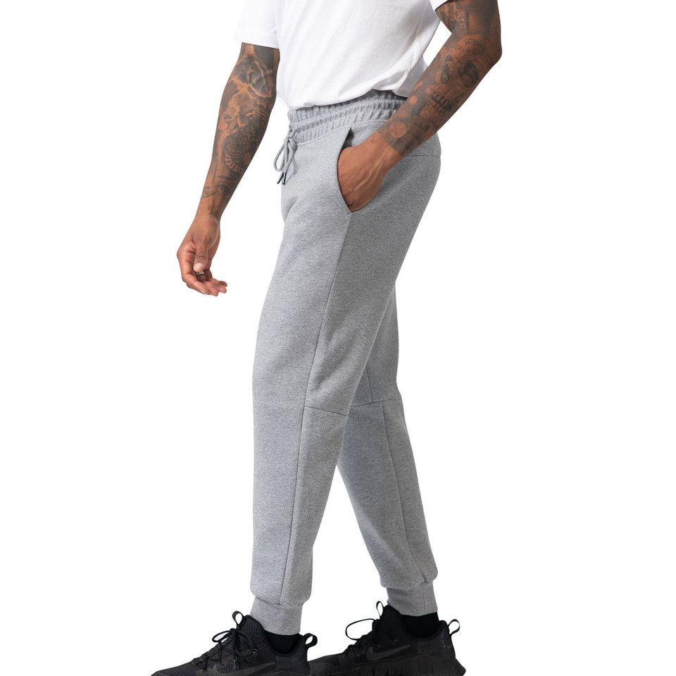 Man wearing grey marle cotton fleece track pants with drawstring waist, side pockets, and ribbed cuffs