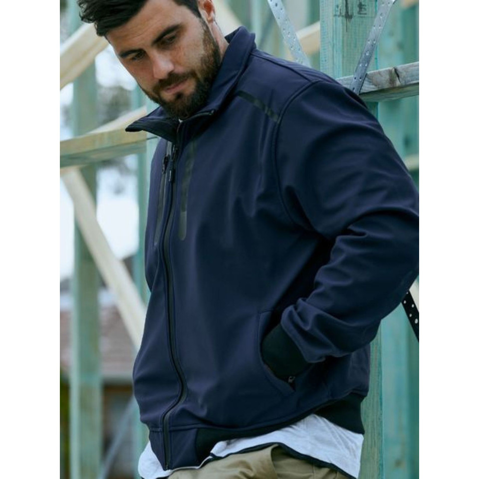 Man wearing navy soft shell bomber jacket with stand collar, full zip and side pockets at construction site