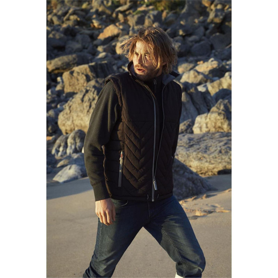 Black padded vest with chevron quilting pattern and full front zip worn over olive hoodie