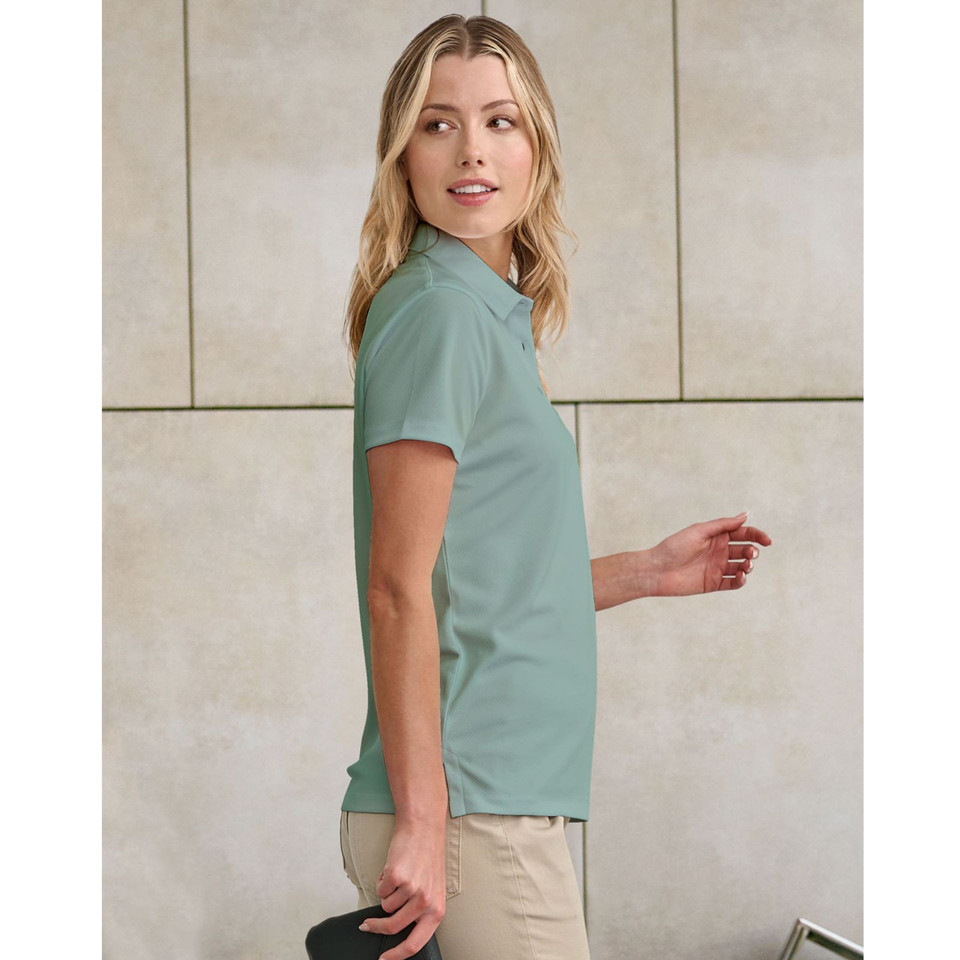 Woman wearing a sage green short-sleeve polo with subtle jacquard texture and classic collar, side profile view