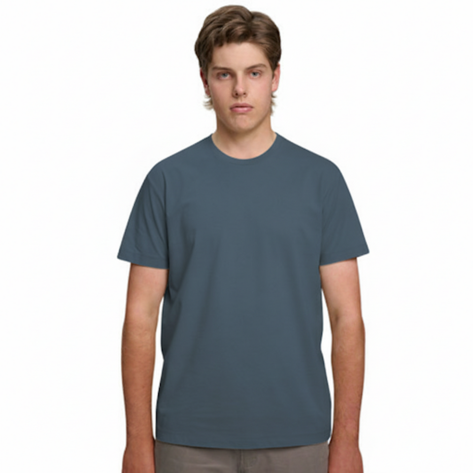 A male model with light brown hair wearing a plain slate blue Soho Men's Premium New Tech Cotton Face T-shirt, standing against a white background.
