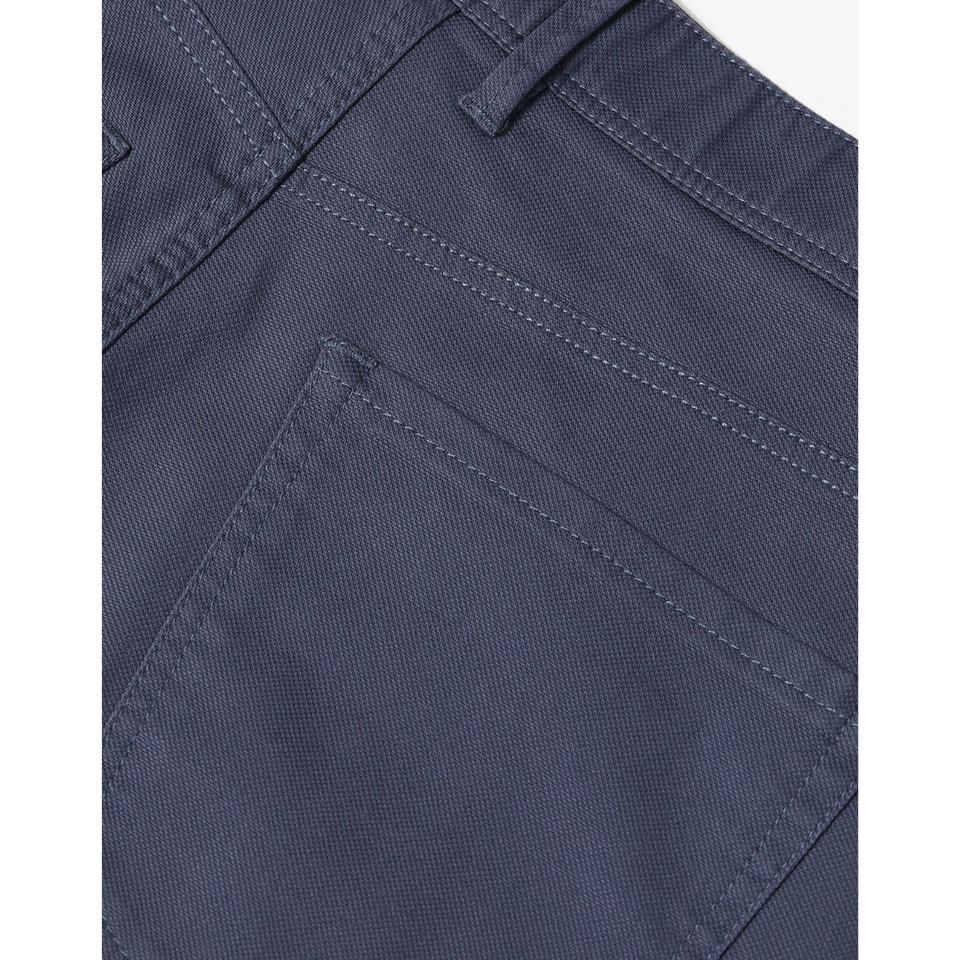 Close-up of slate blue chino pants showing back pocket detail and twill weave fabric texture