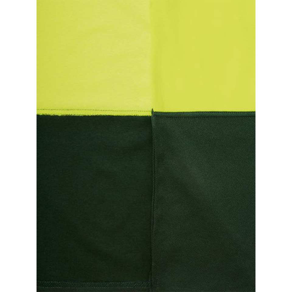 Close-up of hi vis polo shirt hem showing lime yellow and bottle green two-tone colour-block panels