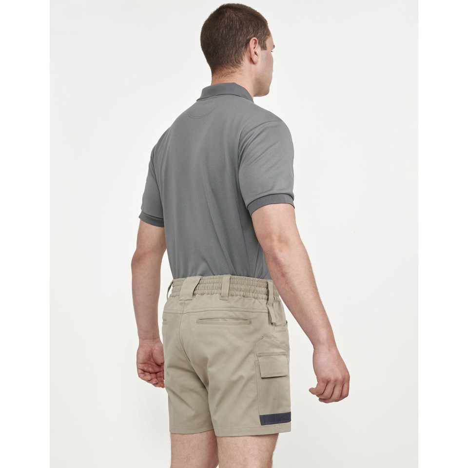 Back view of sand cotton stretch drill work shorts with cuffed hems and charcoal contrast trim, paired with grey polo shirt