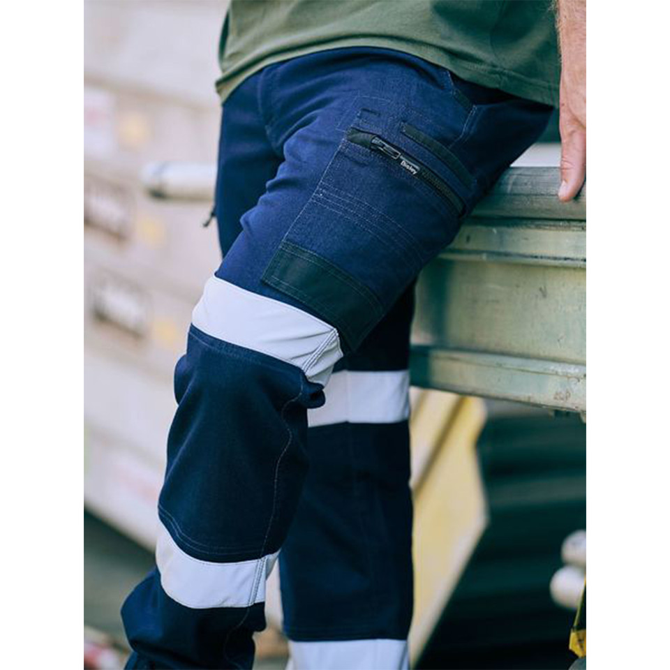 Navy stretch denim cargo pants with white reflective tape detail and cargo pockets with zipper closure