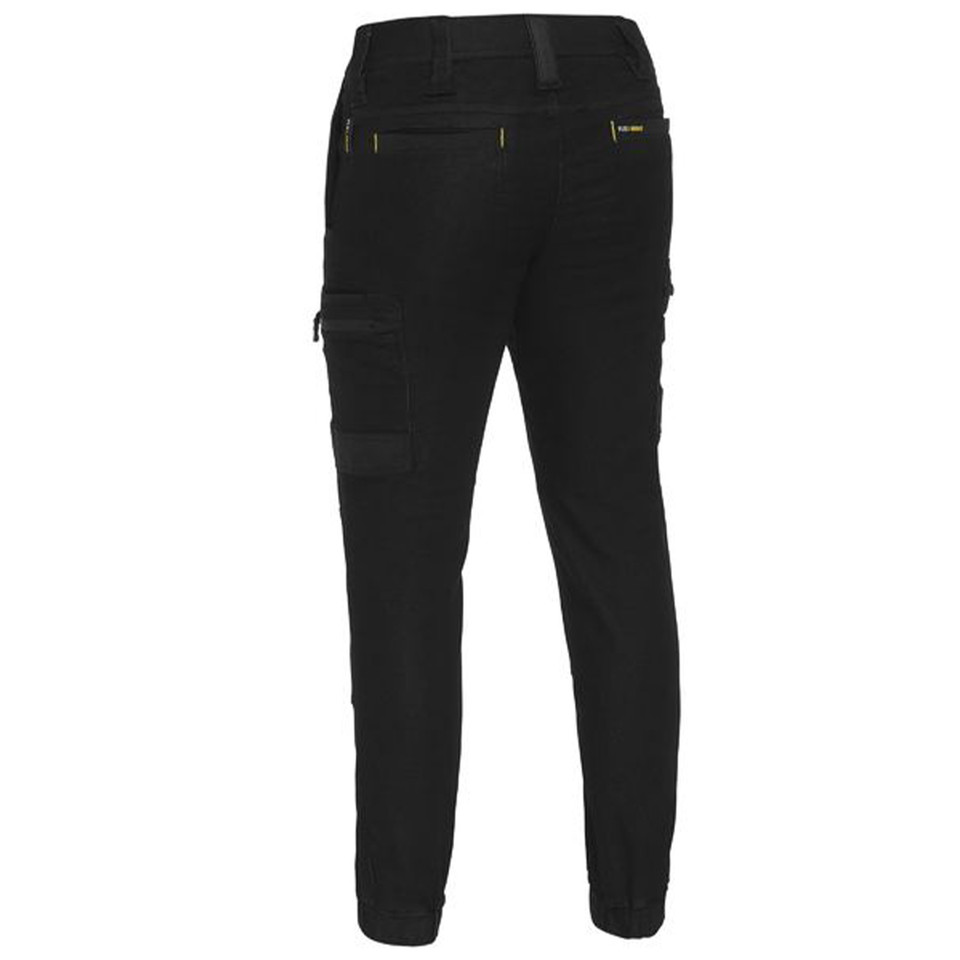 Black stretch denim cargo pants with cuffed ankles, cargo pockets, and gold metal rivets, rear view