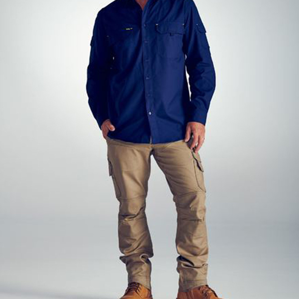 Male model wearing khaki ripstop cargo work pants with multi-pocket detailing and articulated knees