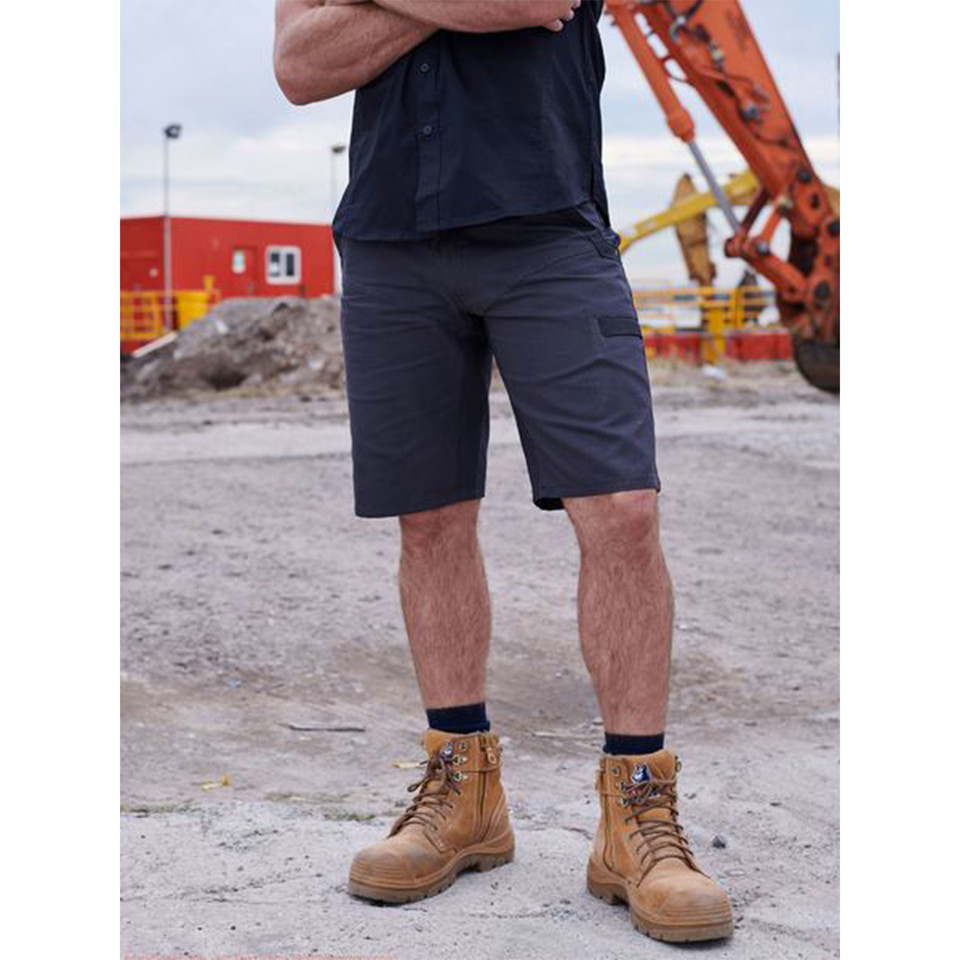 Navy cargo shorts with side pockets and stretch fabric, worn with work boots on construction site