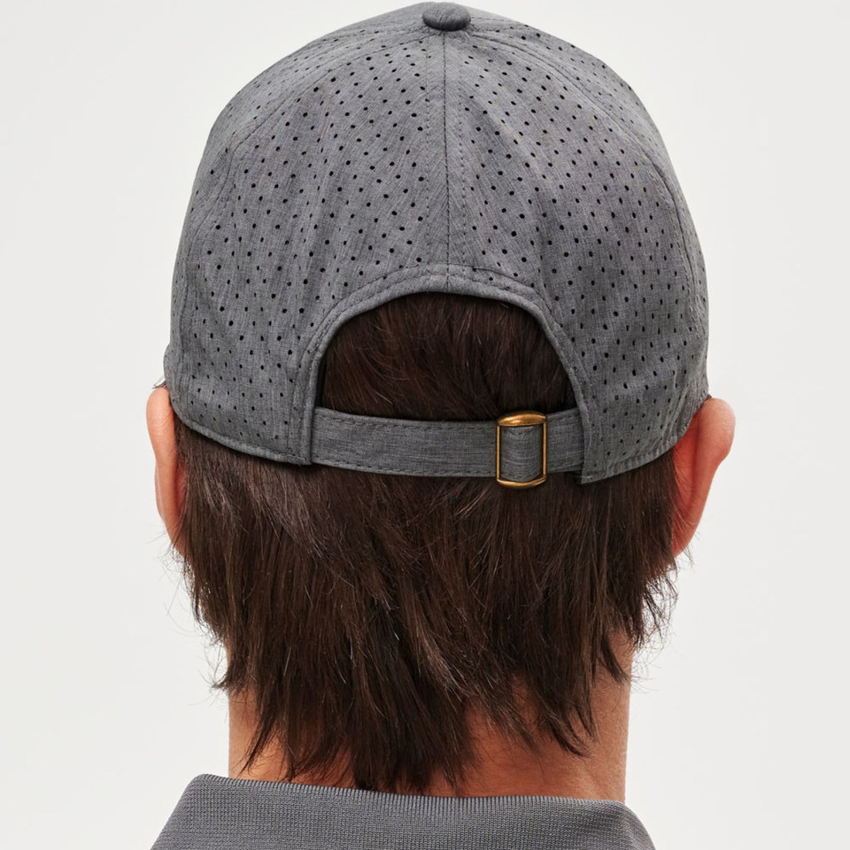 Charcoal grey laser-perforated runners cap rear view showing gold buckle strap closure on model