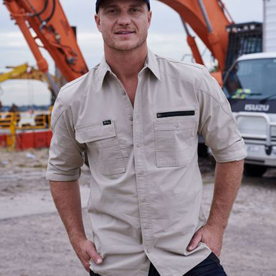 Man in sand ripstop long sleeve work shirt with chest pockets and zip pocket, worn on construction site