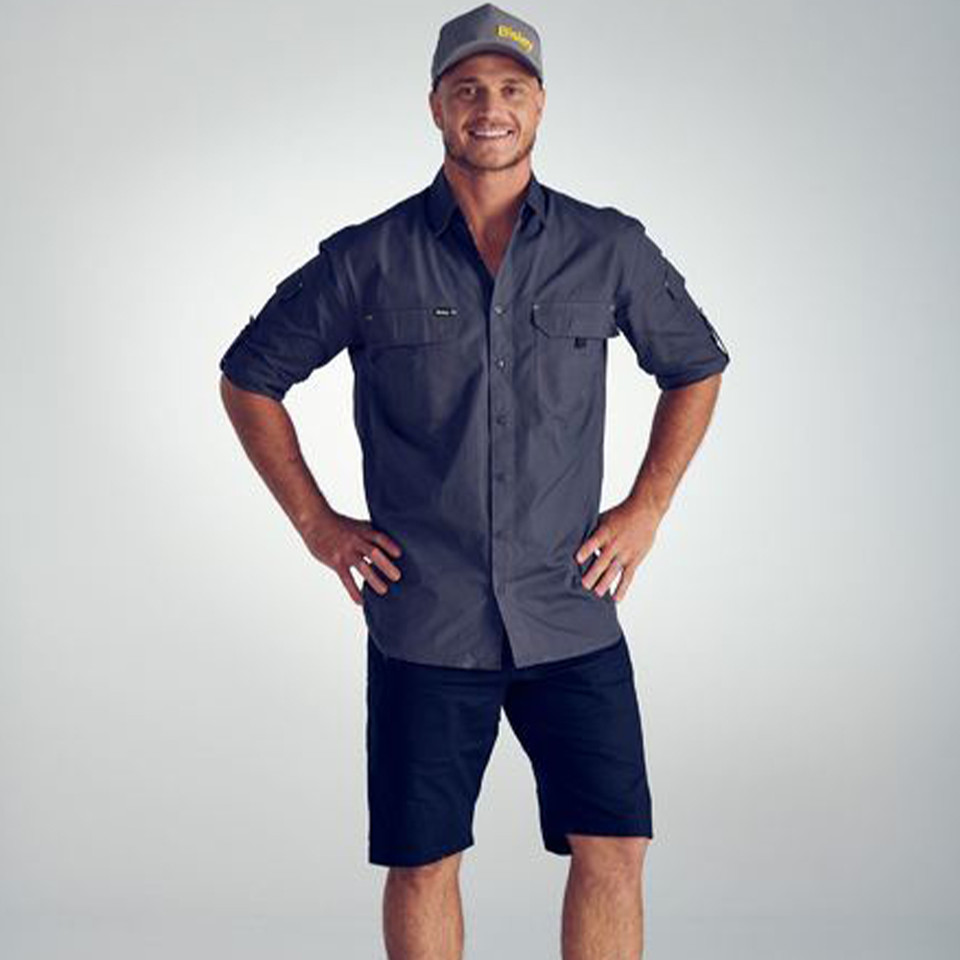 Man wearing charcoal ripstop work shirt with roll-up sleeves, dual chest pockets, and button front