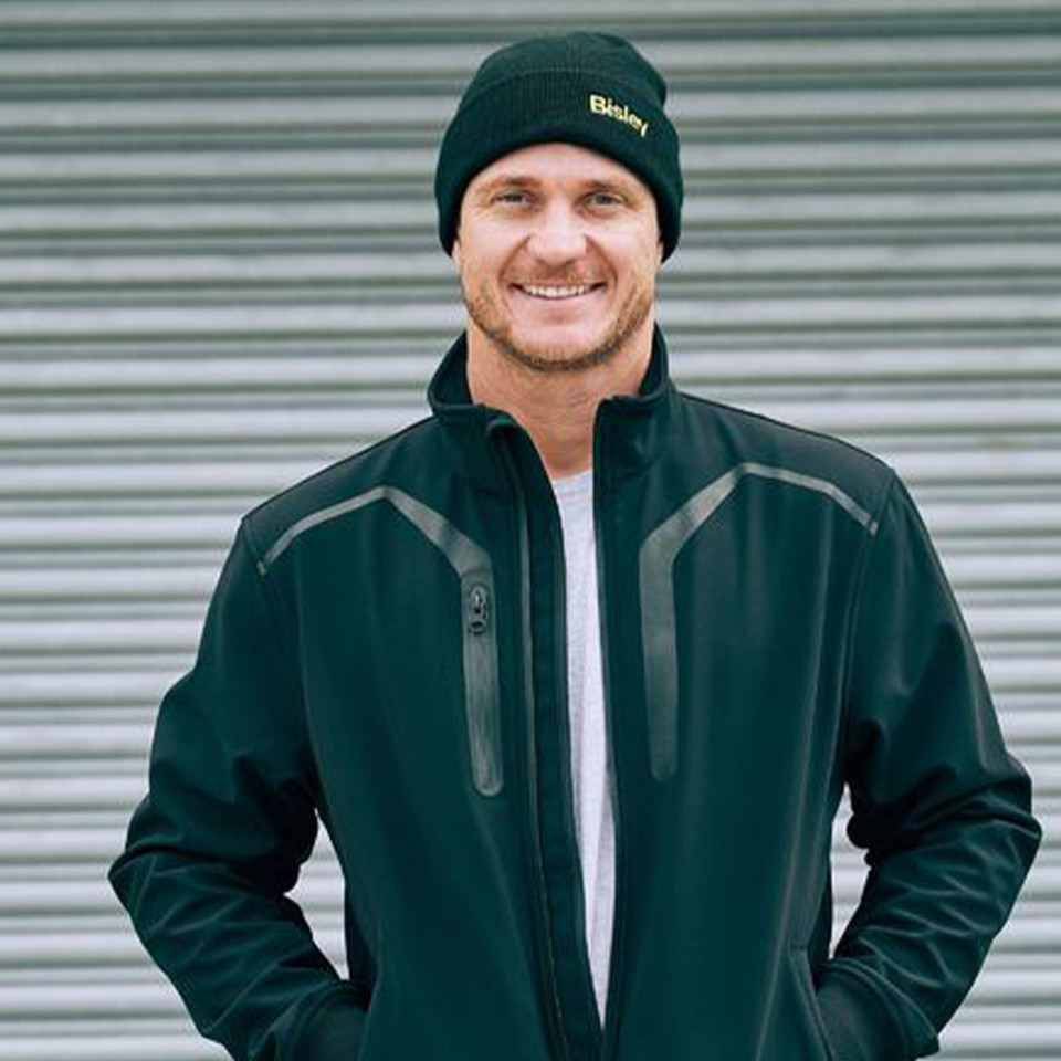 Man wearing black rib knit beanie with folded cuff and yellow Bisley logo embroidery