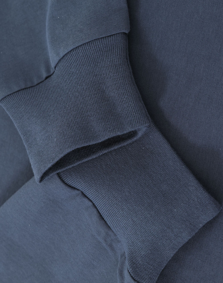 Close-up of slate long sleeve tee showing ribbed cuff and smooth cotton fabric detail