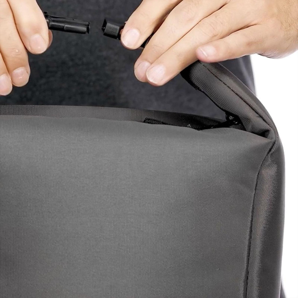 Close-up of charcoal grey cooler bag showing hands opening black zip pocket detail