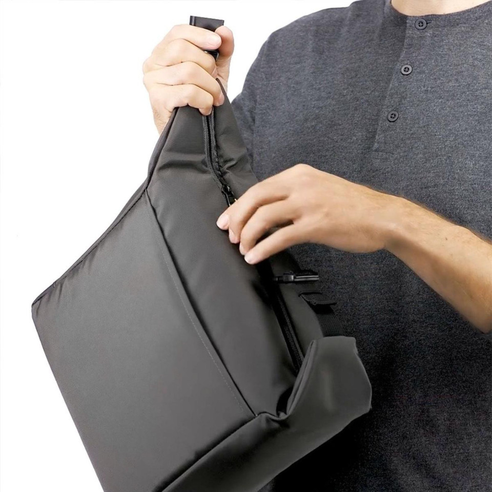Man holding charcoal structured cooler bag showing zippered top opening and moulded base panel