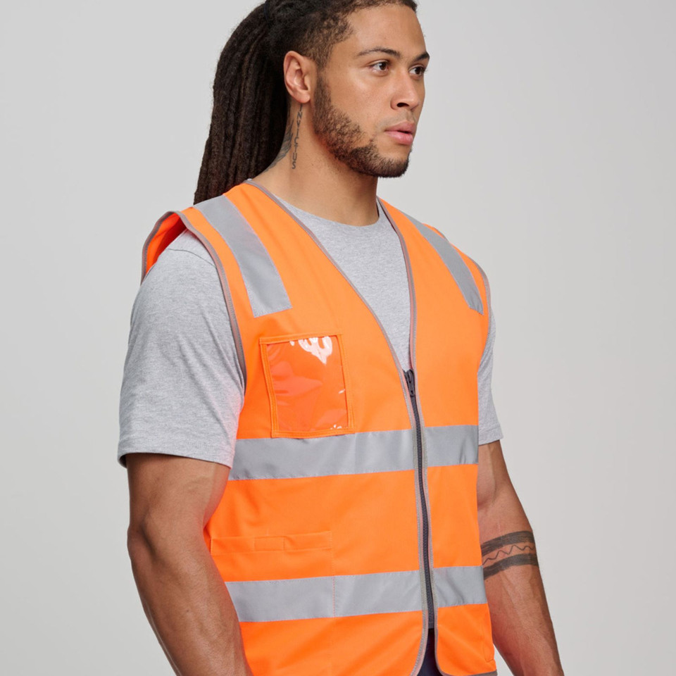 Man wearing fluorescent orange hi-vis safety vest with grey reflective tape, zip front, and clear ID pocket
