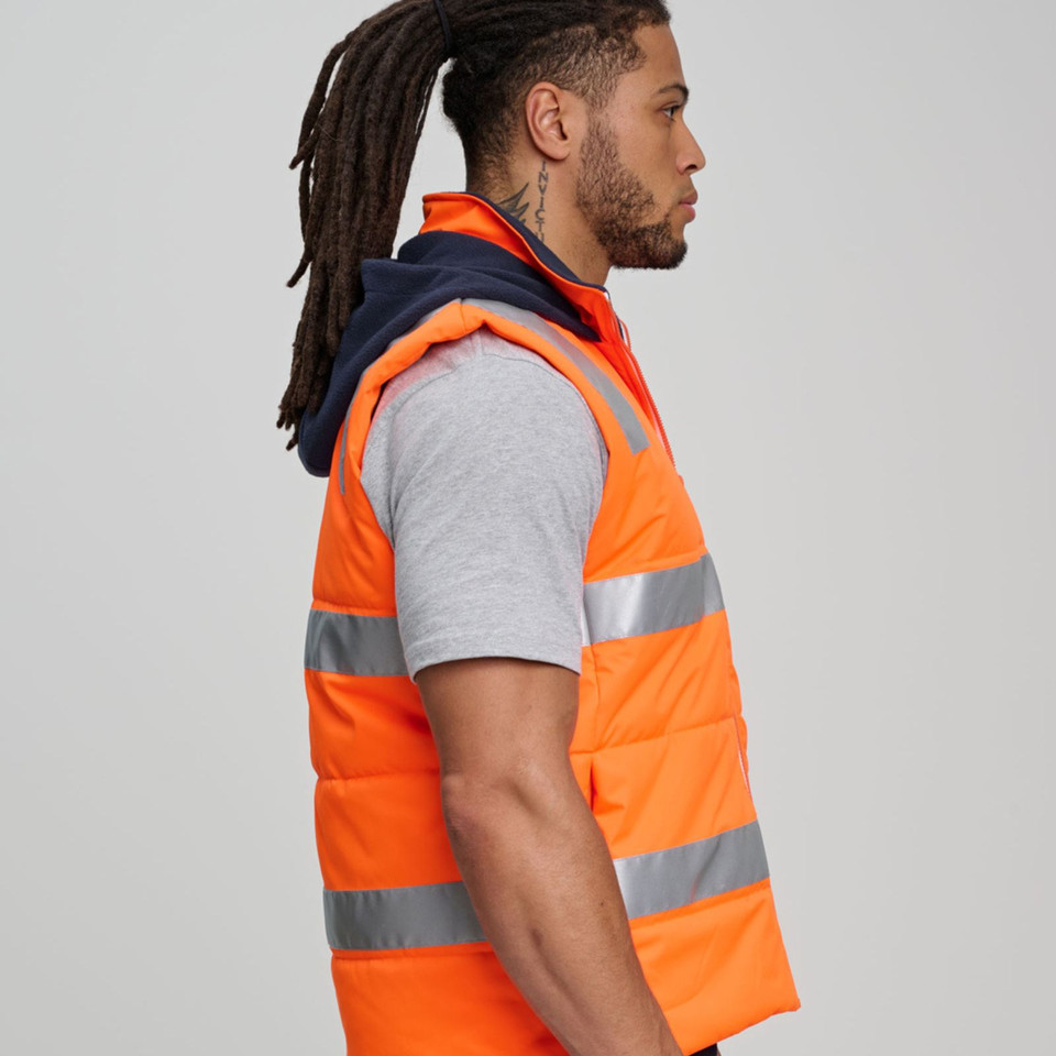 Orange hi-vis puffer vest with reflective tape and navy hood worn over grey polo shirt, side view