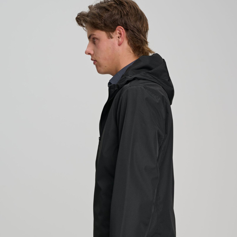 Male model wearing a black hooded waterproof jacket with smooth shell fabric, shown from the side