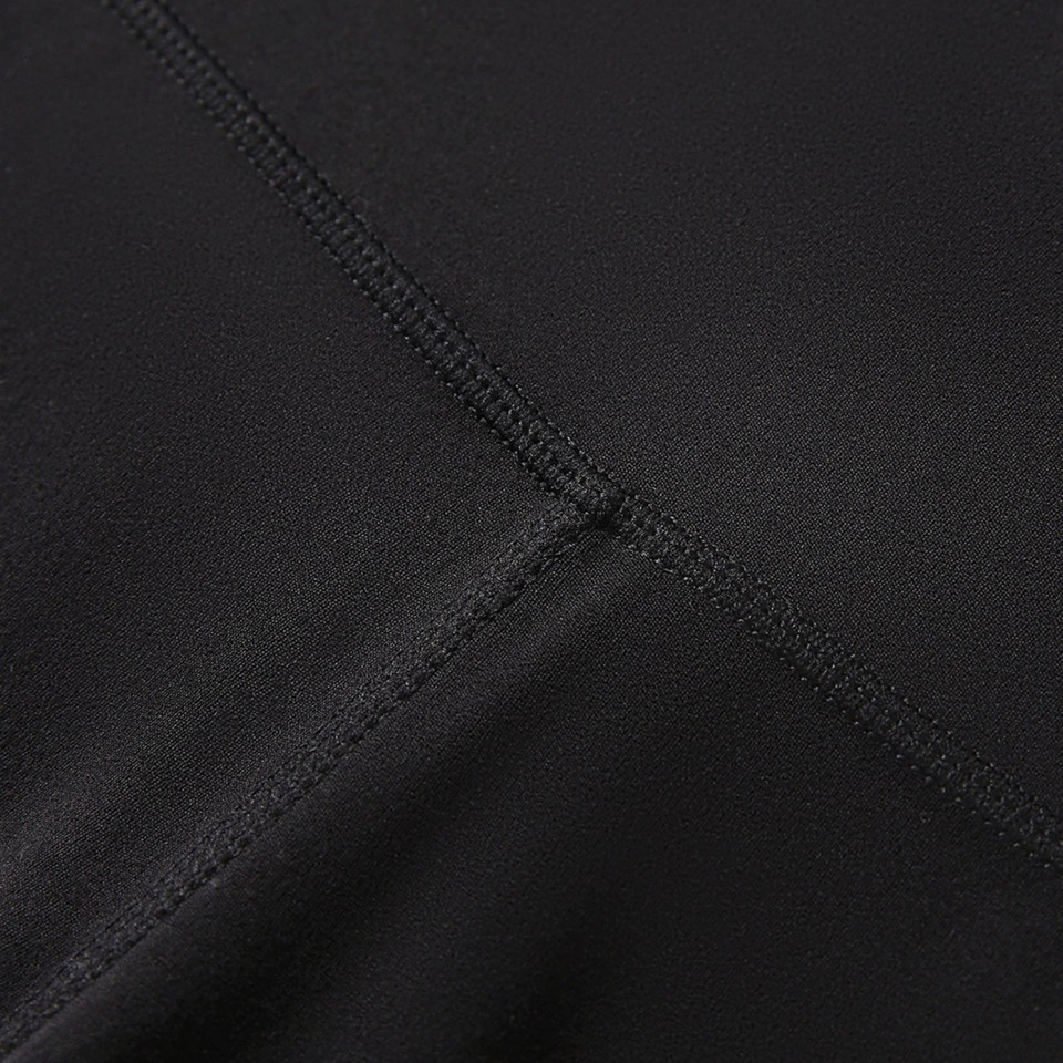 Close-up of black stretch fabric panel seam detail on women's high-rise legging shorts