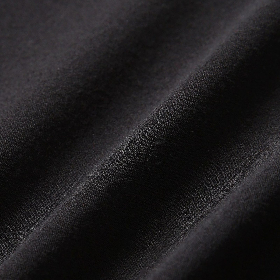 Close-up of charcoal black smooth stretch fabric with soft drape and fine knit texture
