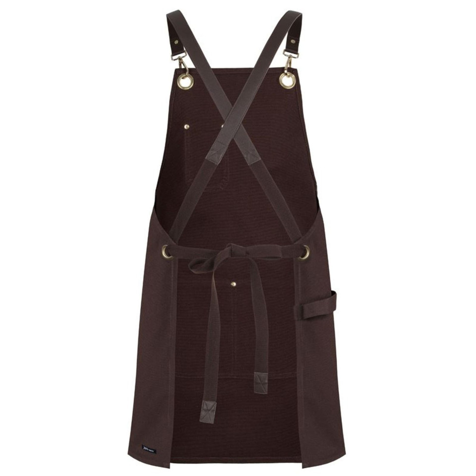 Dark brown canvas apron with crossback straps, brass eyelets, and multiple pockets with tie waist
