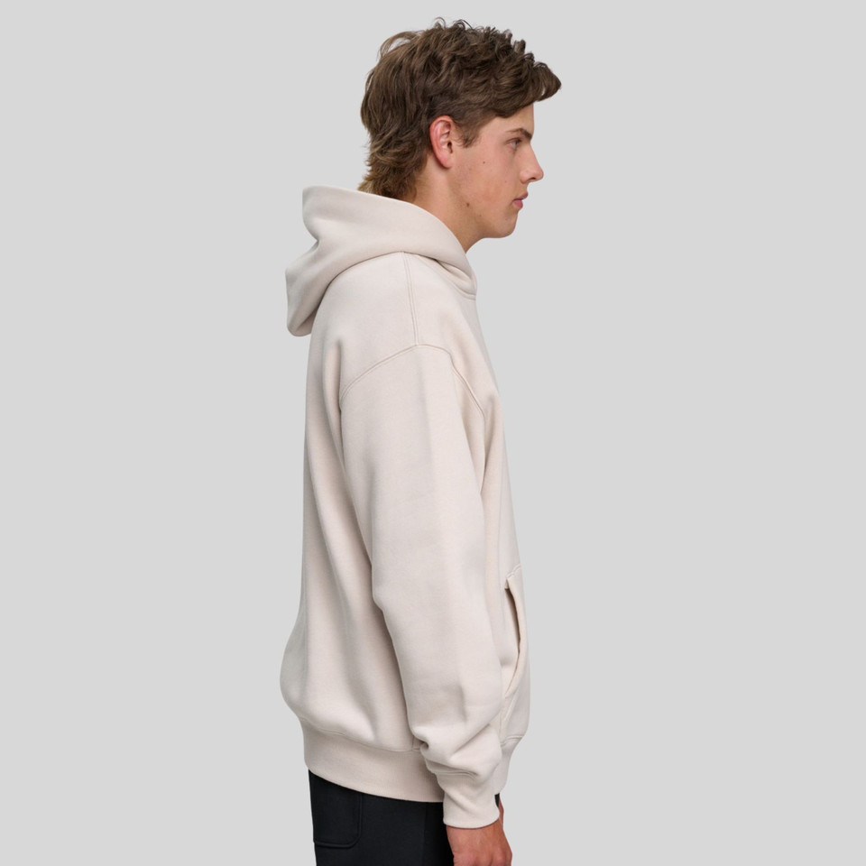 Side view of cream oversized fleece hoodie with kangaroo pocket and relaxed fit