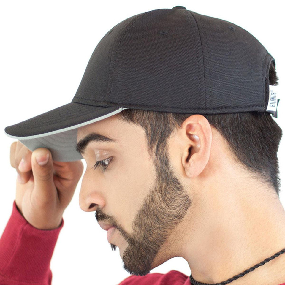 Man holding brim of black structured cap with grey undervisor and white contrast trim, side profile view