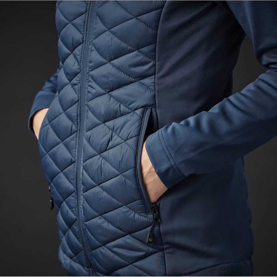 Close-up of steel blue women's insulated jacket showing diamond-quilted front panel, contrast softshell side panel, and zippered hand pocket