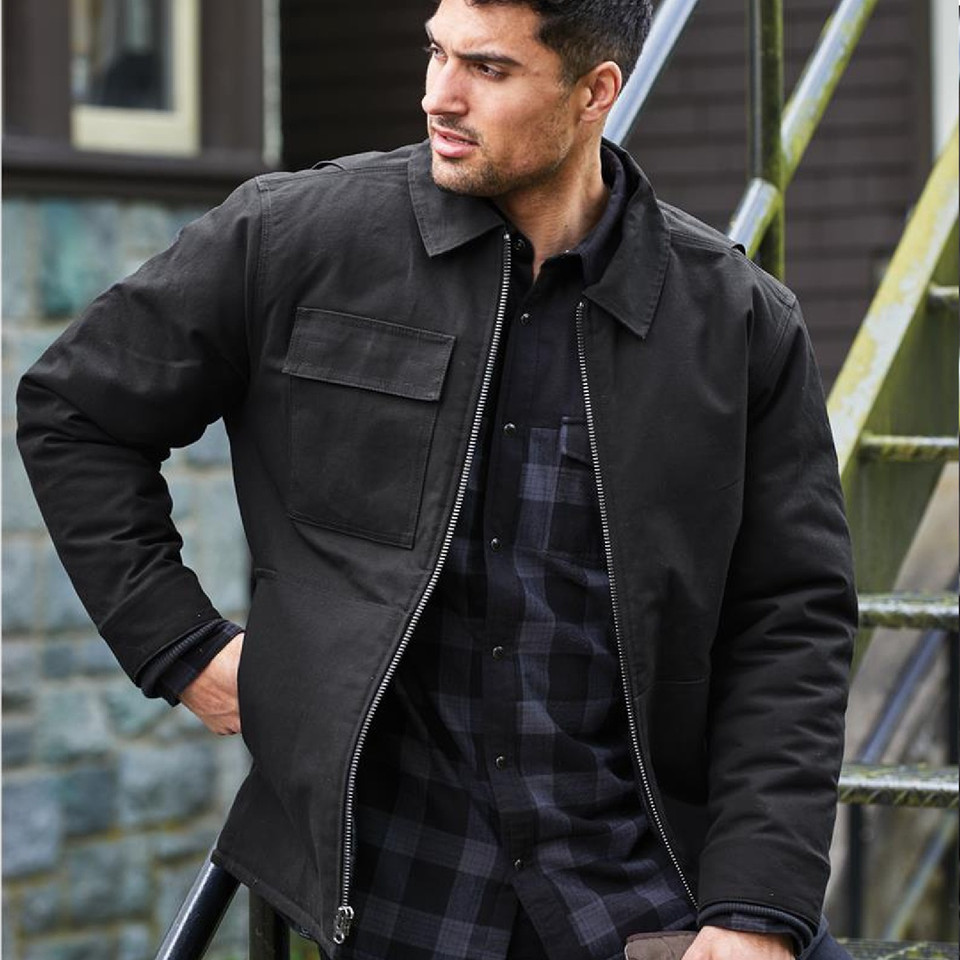 Man wearing black insulated work jacket with point collar, front zip, and chest pocket over plaid shirt